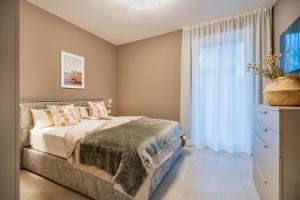 a bedroom with a bed and a window at Indigo Eco Apartments in Bardolino