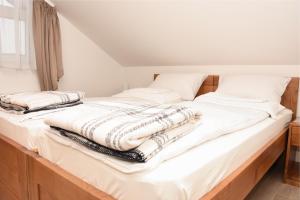 a bed with white sheets and pillows on it at Apartmani Stefan in Vrdnik +80 photos