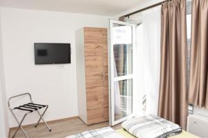 a bedroom with a mirror and a chair next to a window at Apartmani Stefan in Vrdnik