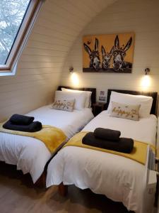 2 Betten in einem Zimmer mit Hörnern an der Wand in der Unterkunft Riding Gate Lodge in Charlton Musgrove