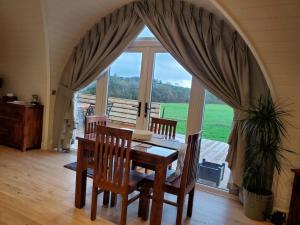 a dining room with a table and chairs and a large window at Riding Gate Lodge in Charlton Musgrove