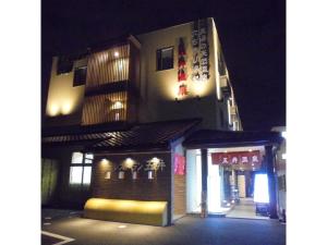 un edificio con un cartel en su costado por la noche en Business Hotel Goi Onsen - Vacation STAY 78238v en Ichihara