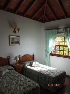 1 dormitorio con 2 camas y ventana en House the Viñas 2 With views of the sea, the mountains and the volcanoes, en Fuencaliente de la Palma