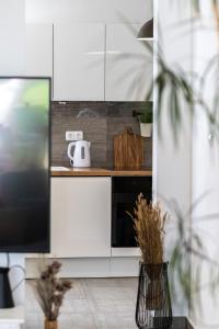 a kitchen with white cabinets and a black microwave at Apartments Juraj in Petrcane