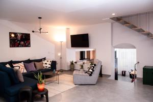 a living room with a blue couch and a chair at Aelia 110 sq.m. luxury apartment in Nafplio