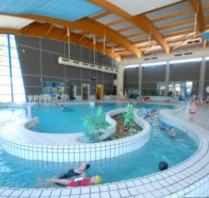 a large indoor swimming pool with people in it at Logement chaleureux, vallée de Villé in Steige