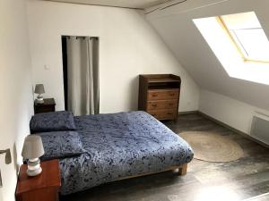 sypialnia z łóżkiem, komodą i oknem w obiekcie Logement chaleureux, vallée de Villé w mieście Steige