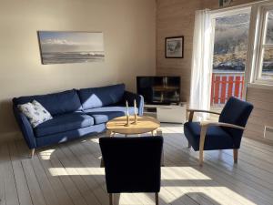 a living room with a blue couch and a table at Brygga på Dønna in Berfjorden