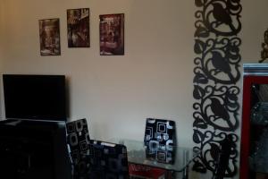 a room with a table and a tv and some pictures at Sofaki Apartments in Thessaloniki