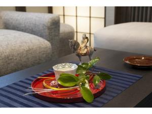 stół z czerwoną płytką z rośliną w obiekcie Daimaru-un - Vacation STAY 56043v w mieście Kanazawa
