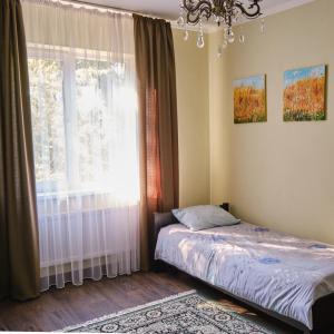 1 dormitorio con cama y ventana en Садиба Лісова en Podgorodtsy