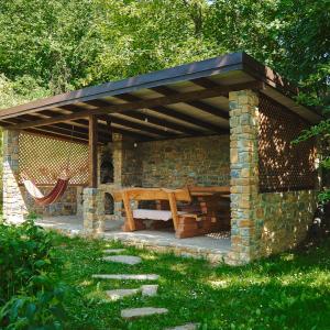 - un pavillon avec une table en bois et un banc dans l'établissement Садиба Лісова, à Podgorodtsy