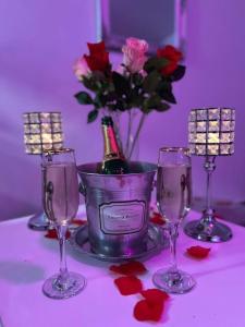 una botella de champán en un cubo con tres copas de vino en Les Secrets d'Amandine en Troguéry