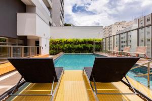 un patio de apartamentos con sillas y una piscina en ESD - E-Side Vila Madalena - Anora Spaces Residenciais, en São Paulo
