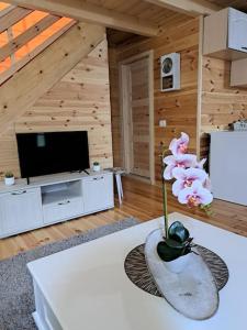 a living room with a vase with a flower on a table at Olive & sea, Luxury two bedrooms cabin for 8 in Ulcinj