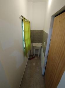 une salle de bain avec un lavabo et un rideau de douche jaune dans l'établissement Apart La Mochita III, à San Fernando del Valle de Catamarca
