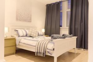 a bedroom with a white bed and a window at Apartment in West Yorkshire 59 in Keighley
