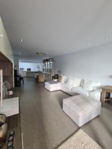 ロス・クリスティアーノスにあるNosotros Luxury Villaのリビングルーム(白いソファ付)、キッチンが備わります。