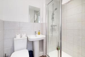 e bagno con doccia, servizi igienici e lavandino. di Modern 5 Bedroom 3 Bathroom Serviced House Aylesbury with Parking By 360Stays ad Aylesbury