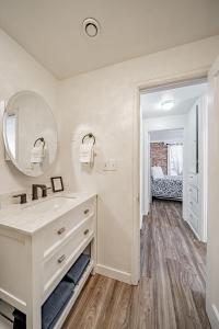 een witte badkamer met een wastafel en een spiegel bij Suites of Lava Hot Springs in Lava Hot Springs