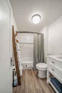 a white bathroom with a toilet and a sink at Suites of Lava Hot Springs in Lava Hot Springs