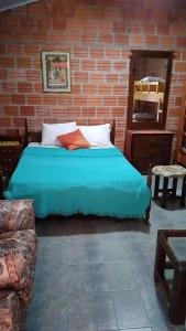 ein Schlafzimmer mit einem Bett und einer Ziegelwand in der Unterkunft Posada Turística Las Orquídeas in Cambyretá