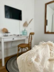 a bedroom with a desk and a bed with a white dress at Wohlfühl-Apartment am Paradiesberg in Radebeul