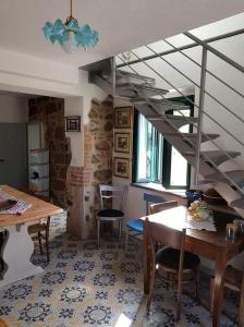 un soggiorno con scala, tavolo e sedie di Casa Matilda - Abbasanta - Sardegna - IUN R4877 ad Abbasanta