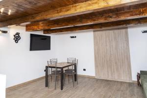 a room with a table and chairs and a tv at Artisti Home Naples in Naples