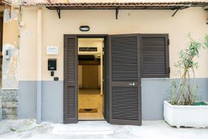 a door to a building with black shutters at Artisti Home Naples in Naples