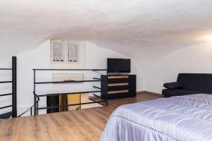 1 dormitorio con 1 cama, TV y sofá en Artisti Home Naples, en Nápoles