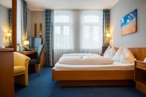 ein Hotelzimmer mit einem Bett und einem Schreibtisch in der Unterkunft Alte Mühle Hotel & Restaurant in Rödental