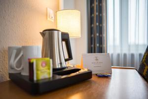 eine Kaffeemaschine auf einem Tisch in einem Hotelzimmer in der Unterkunft Alte Mühle Hotel & Restaurant in Rödental