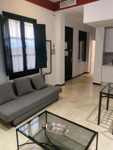 een woonkamer met een bank en een glazen tafel bij Apartament Alameda center in Sevilla