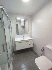 ein weißes Bad mit einem Waschbecken und einer Dusche in der Unterkunft Alta Vista - apartamento con 2 dormitorios y vista al mar in Torrevieja