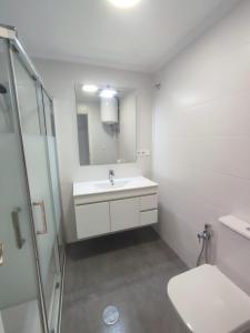 a white bathroom with a sink and a shower at Alta Vista - apartamento con 2 dormitorios y vista al mar in Torrevieja