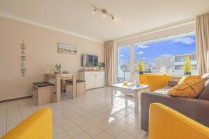 ein Wohnzimmer mit einer Couch und einem Tisch in der Unterkunft Ferienwohnungen im Haus Strandburg Grömitz in Grömitz
