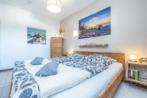 ein Schlafzimmer mit einem Bett und einem Gemälde an der Wand in der Unterkunft Ferienwohnungen im Haus Strandburg Grömitz in Grömitz