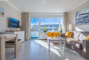 ein Wohnzimmer mit einer Couch und einem Tisch in der Unterkunft Ferienwohnungen im Haus Strandburg Grömitz in Grömitz