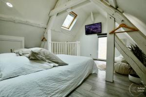 a bedroom with a white bed and a window at Chez Marcel in Le Vaudreuil