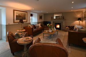 a living room filled with furniture and a fireplace at Kipney Farmhouse with hot tub in Perth
