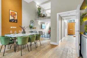 a dining room with a table and green chairs at Be London - The Islington Residences in London