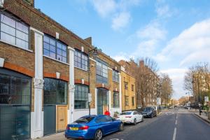 a blue car parked on a street next to buildings at Be London - The Islington Residences in London