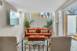a living room with an orange couch and a table at Be London - The Islington Residences in London