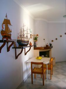 a room with a table and a model ship on the wall at Villa En Rose in Ravello