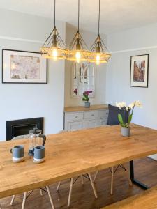 uma sala de jantar com uma mesa de madeira e luzes em Muller residence em Bristol