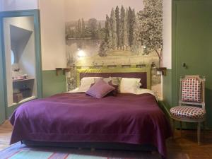 アヴァロンにあるB&B Vassy Etauleのベッドルーム1室(紫色の毛布と椅子付きのベッド1台付)