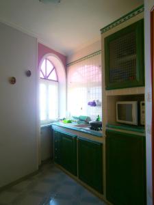 a kitchen with green cabinets and a microwave at Villa En Rose in Ravello +31 photos