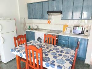 cocina con mesa y sillas y cocina con armarios azules en Casa Azul en Costa de Antigua
