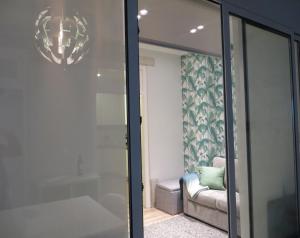 een badkamer met een glazen douche en een bank bij Apartamento Roma in Lissabon